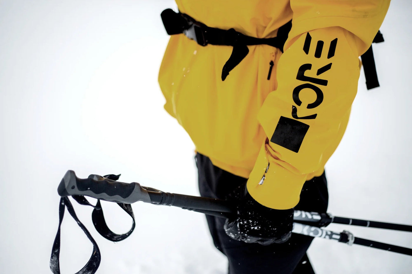 Power Ski - Schwarze Skistöcke vor gelber Skijacke