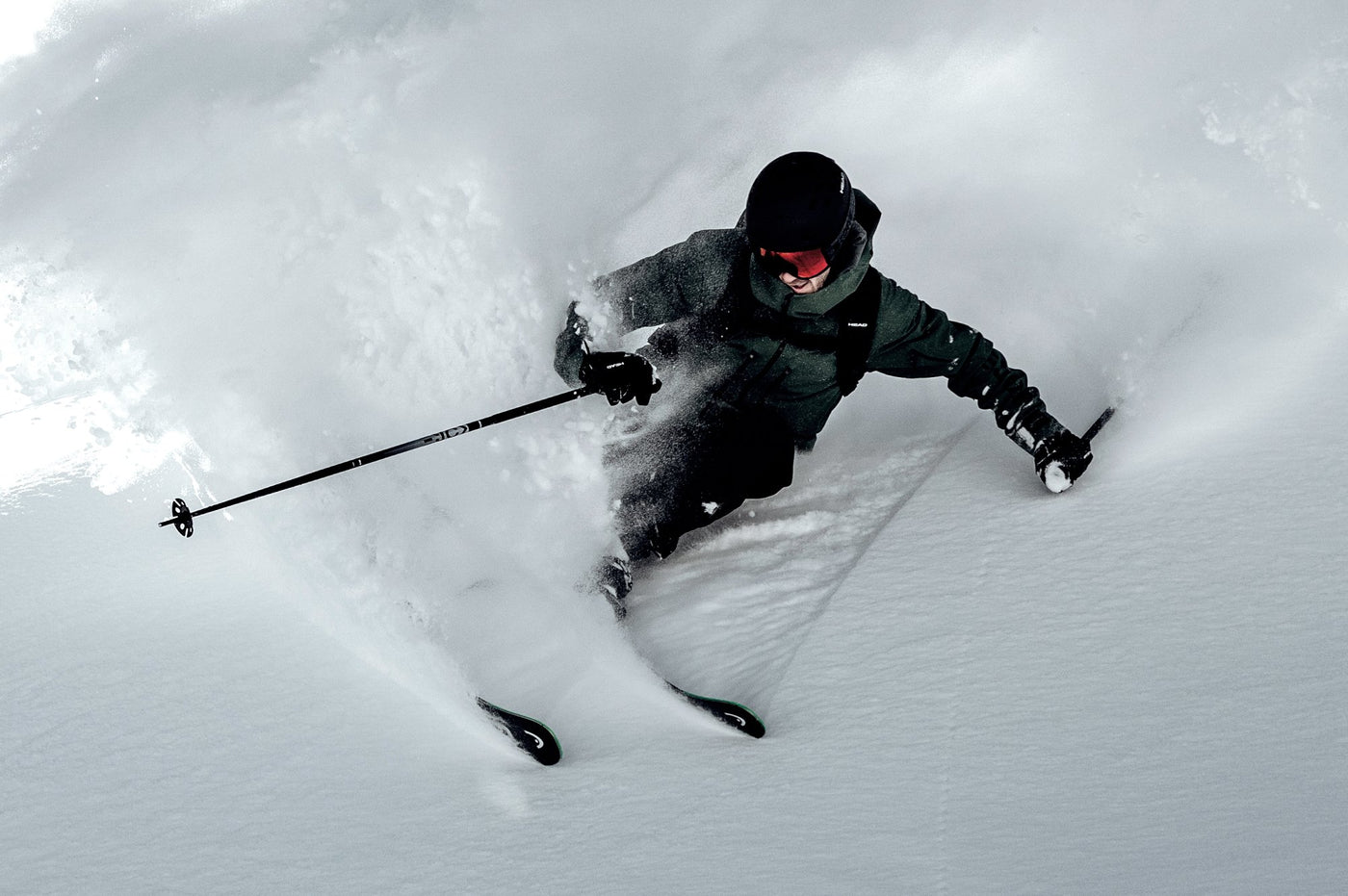 Power Ski - Mann mit Skihelm fährt auf Freeride Ski durch Tiefschnee