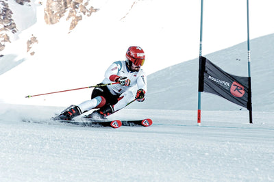 Power Ski - Skirennfahrer in Rennanzug umkreist Tor auf Raceski