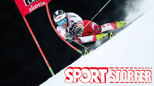 Skirennläufer brettert an Tor vorbei, darunter befindet sich das Sport Storfer-Logo