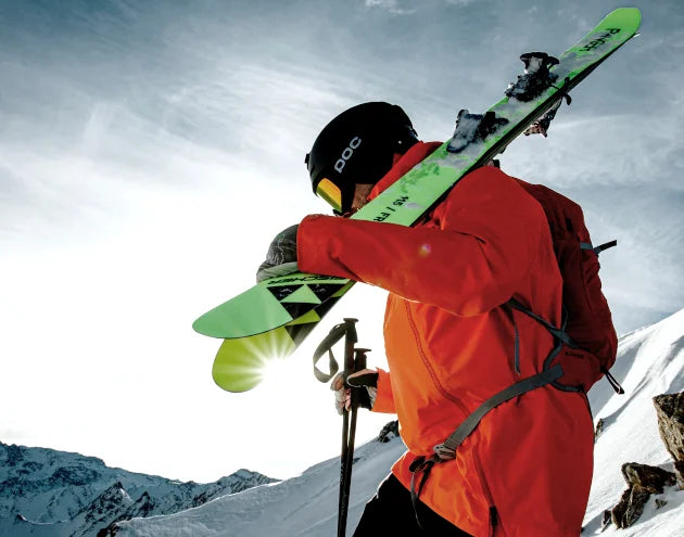Power Ski - Mann mit Skihelm und Skibrille trägt Freeride Ski auf Schultern