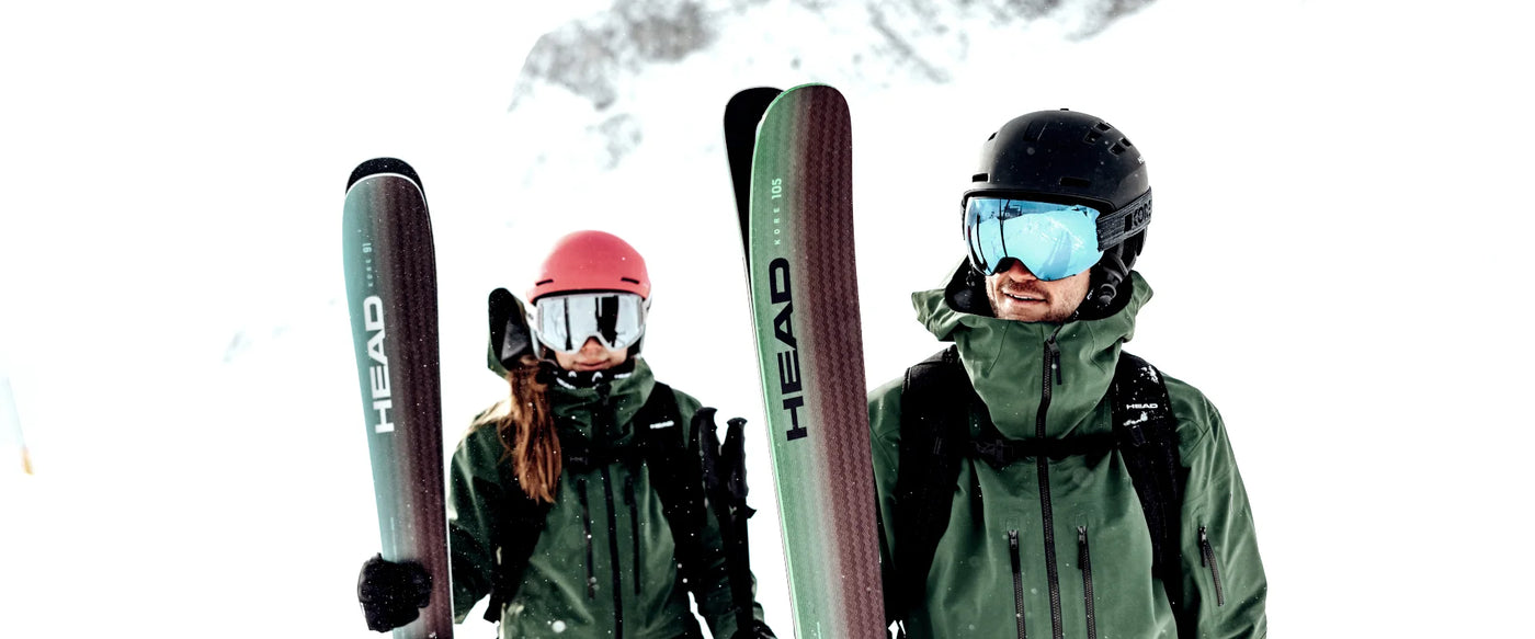 Power Ski - Mann und Frau mit Skihelmen und Skibrillen tragen Ski