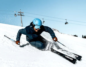 Power Ski - Mann mit Skihelm und Skibrille macht Schwung auf Sport Carvern